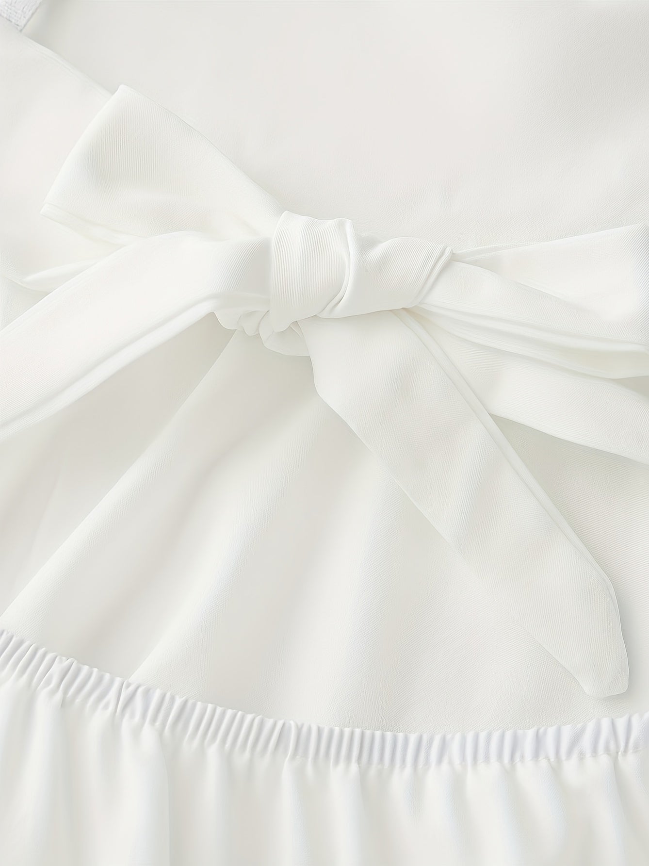 Vestido mini de tirantes finos de encaje blanco con elegante lazo en la espalda